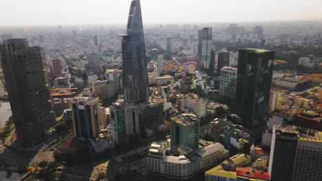 drone shot through ho chi minh city, vietnam during sunset with the bitexco tower