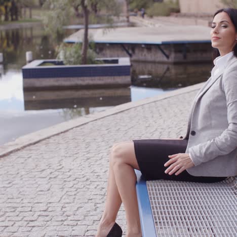 Business-woman-relaxing-near-canal