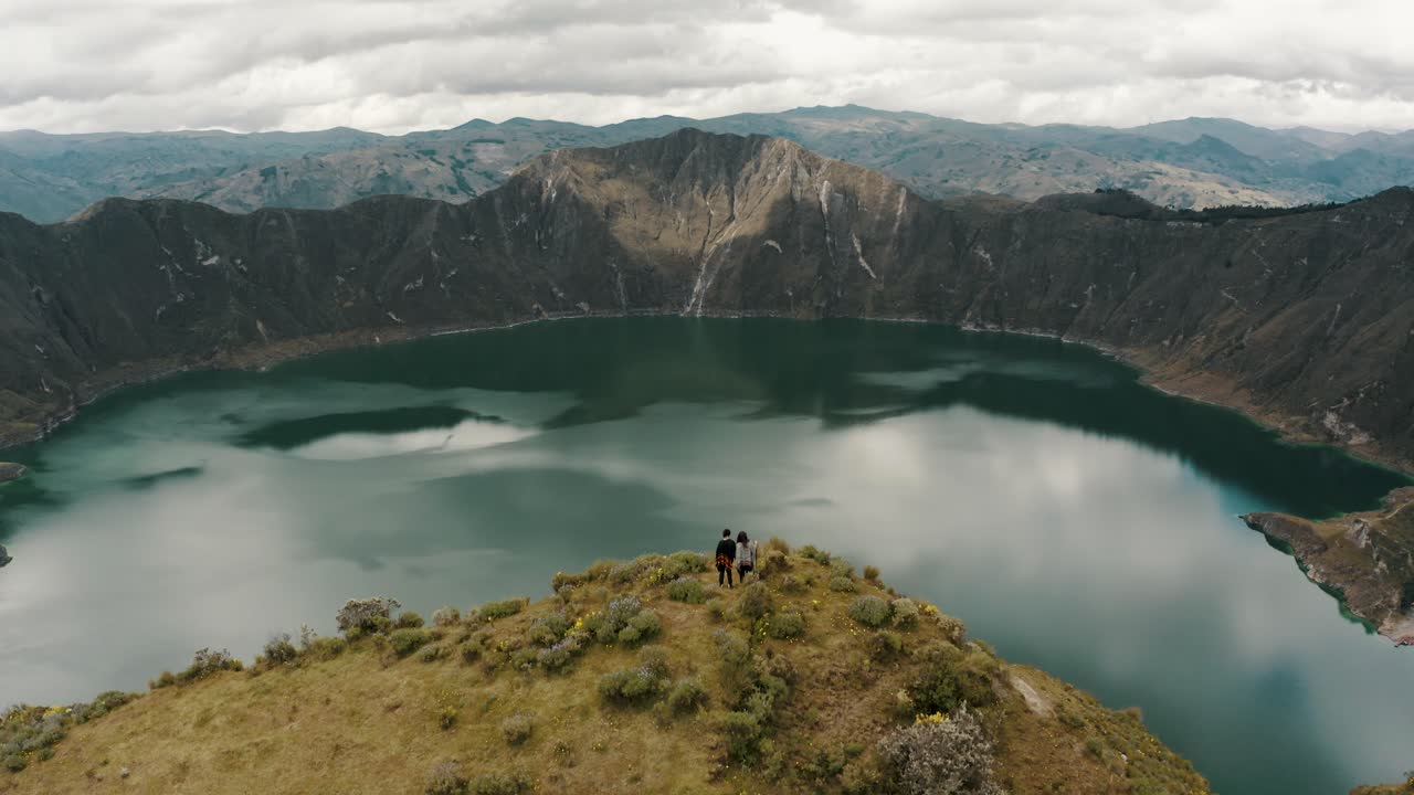 Turisti che si godono la vista panoramica del Lago Quilotoa in Ecuador - ripresa aerea con drone