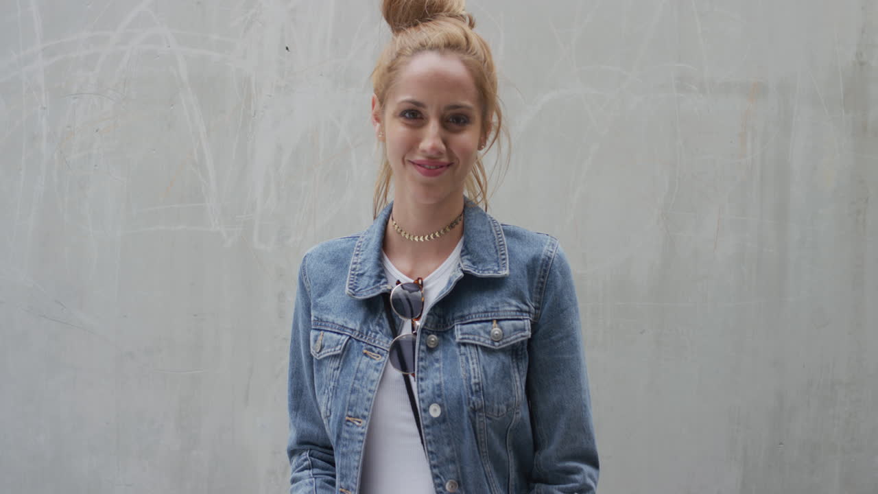 retrato de uma mulher jovem bonita sorrindo, brincalhona, vestindo uma moda de jeans elegante, desfrutando de um estilo de vida urbano independente