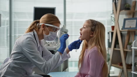doctor taking saliva sample in examination room closeup. child health checkup