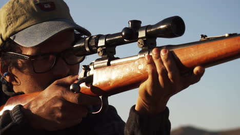 un hombre americano disparando una pistola de rifle en el campo de tiro, un primer plano en cámara lenta