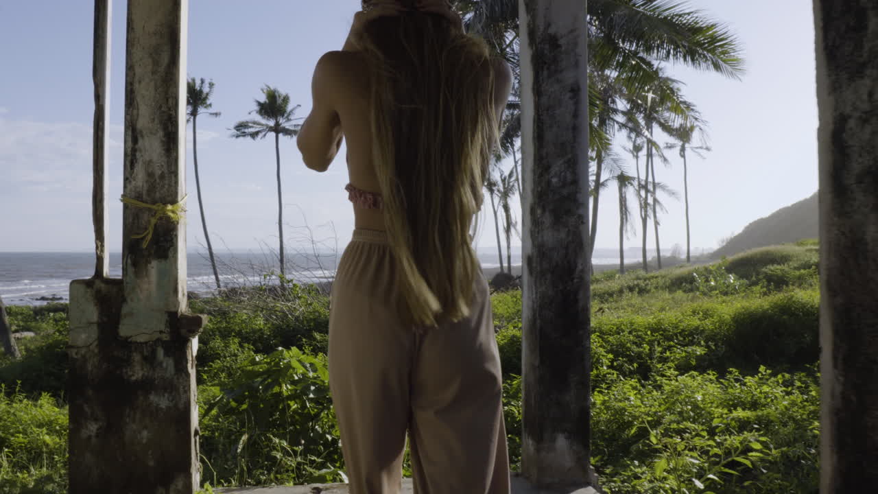 Cute blonde girl walking through abandoned house near beach
