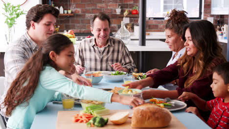 familia de varias generaciones disfrutando de la comida alrededor de la mesa en casa