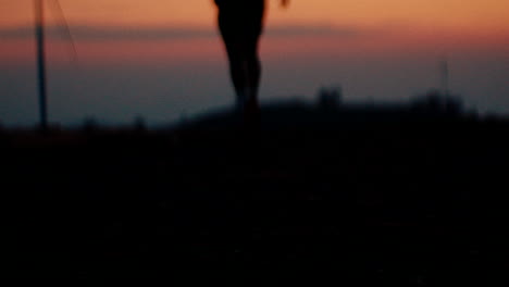 Silhouette of a Person Running/Standing at Sunset near Windmills
