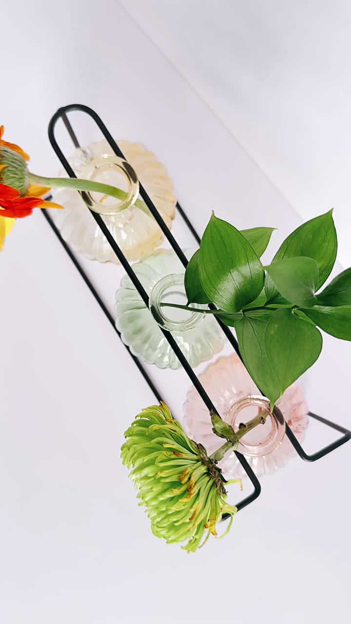 arreglo de flores coloridas en jarrones en un soporte de metal