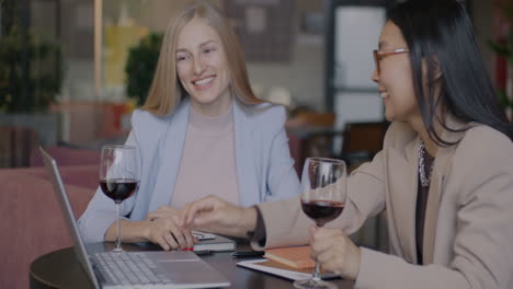 businesswomen networking over wine in a cafe