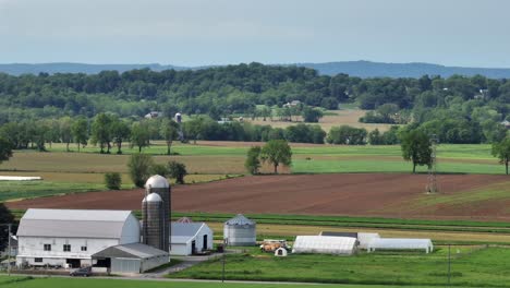 Panorama drone shot of American farmer houses in American countryside. Sunny day in USA. Spring season. Agricultural theme.