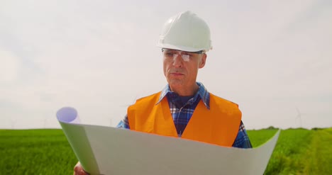 ingeniero analizando el plan mientras observa el concepto de energía ecológica de la granja de molinos de viento 11