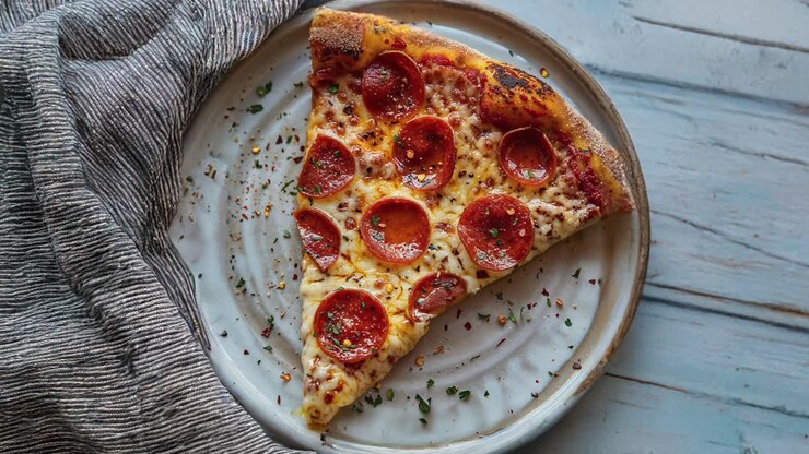 Fetta di pizza ai peperoni su tavolo di legno rustico con tovaglia