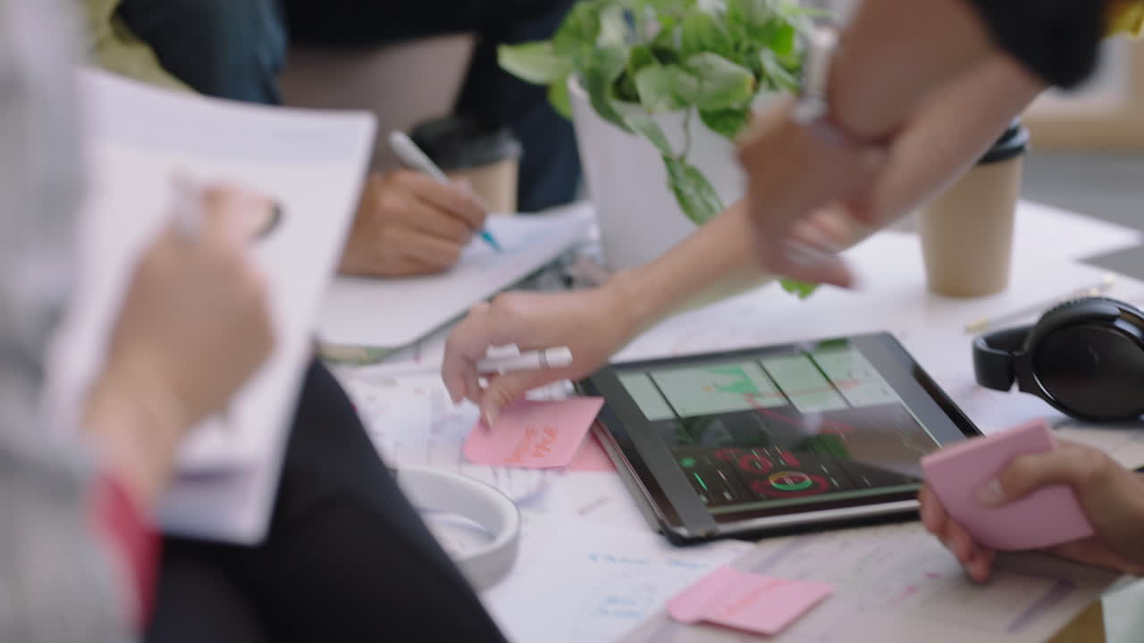 가까운 손 엔지니어들은 디지털 태블릿 컴퓨터를 사용하여 피트니스 앱 소프트웨어를 개발합니다. 스타트업 사무실 회의에서 아이디어를 공유하는 디자인 솔루션 브레인스토밍