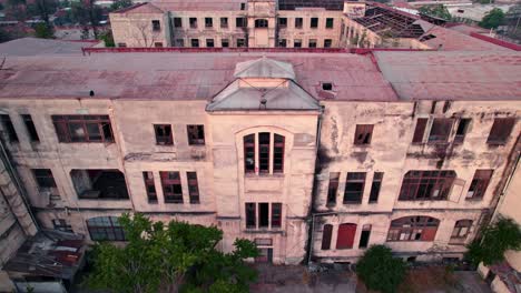 drone panoramic establishing shot of abandoned hospital building medical complex square at ex maternity room