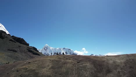 aerial view of hikers trekking through the high andes near ausangate. snow-covered peaks, rugged terrain, and breathtaking natural beauty in remote southern peru