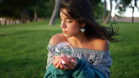 una hermosa hechicera sosteniendo una mágica bola de cristal brillante con una mirada encantadora y misteriosa