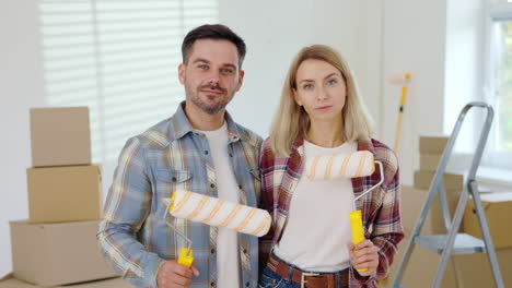 una pareja pintando su nueva casa.