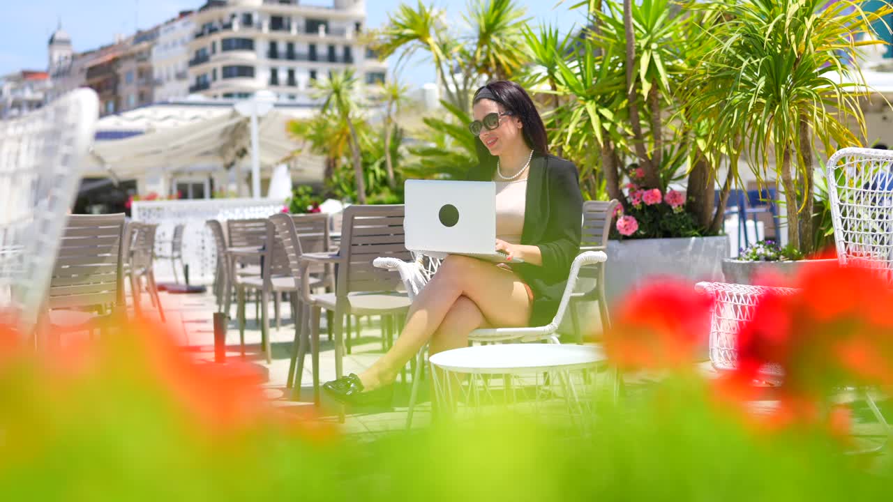야외 카페에서 노트북으로 일하는 여자