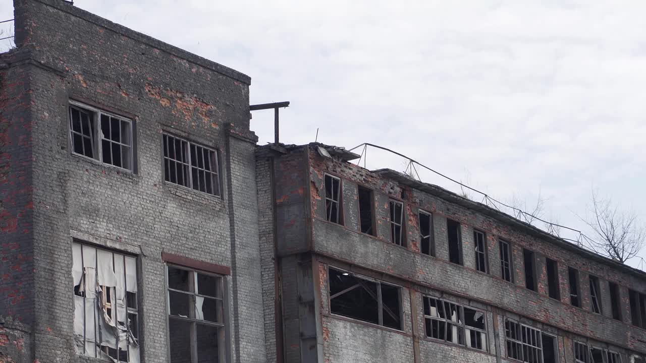 Very old abandoned and ruined building. Broken windows, cracked walls. Consequences of the war. Handheld shooting