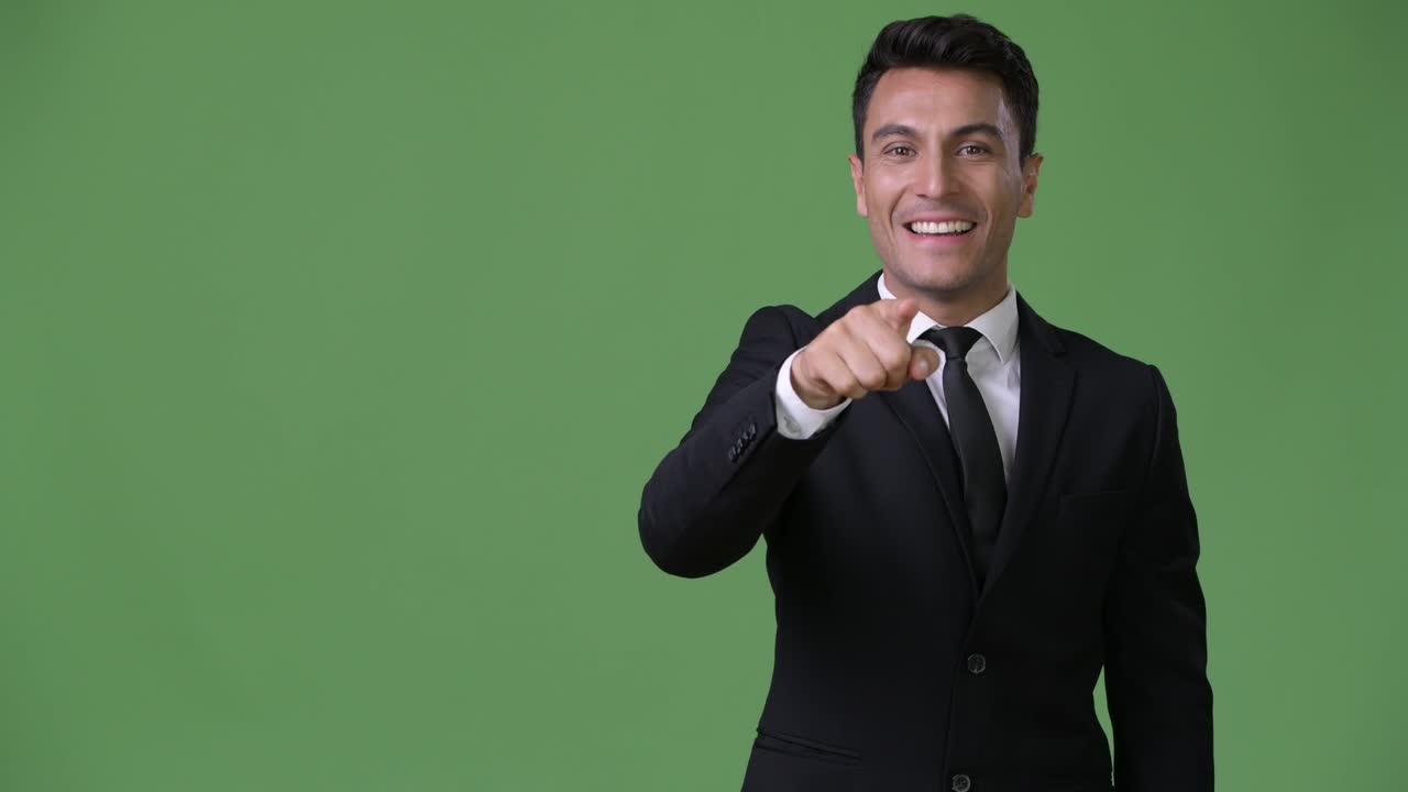 joven y guapo hombre de negocios hispano contra un fondo verde