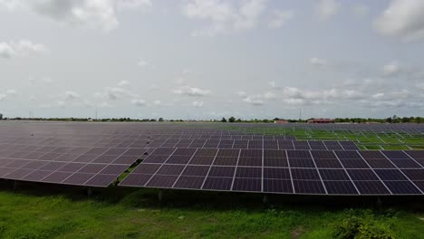 Panorama-shot-of-a-green-field-with-installed-photovoltaic-panels-from-nawec-tbea-power-plant-under-construction-in-Jambur,-The-Gambia-for-sustainable-energy-sources-and-environmental-protection