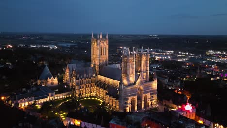 Aerial-drone-video-of-the-iconic-Lincoln-Cathedral-in-Lincolnshire,-UK,-at-dusk,-illuminating-its-magnificent-Gothic-architecture