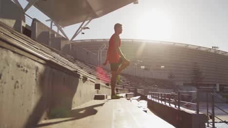 caucasian athlete stretching in stadium