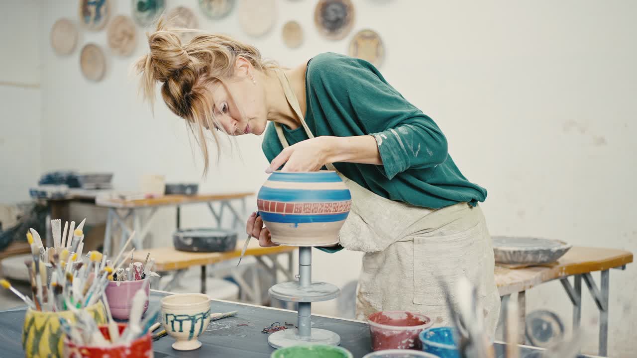 초점을 맞춘 여성 도자기가 도자기 스튜디오에서 손으로 만든 도자기를 장식하고, 추적, 느린 동작