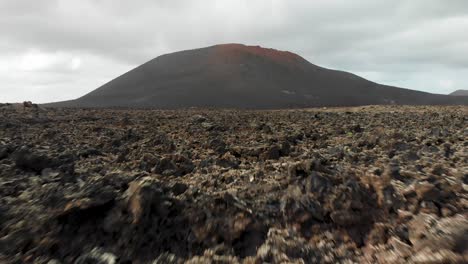 Flying-low-and-fast-towards-a-hill-over-volcanic-rocks