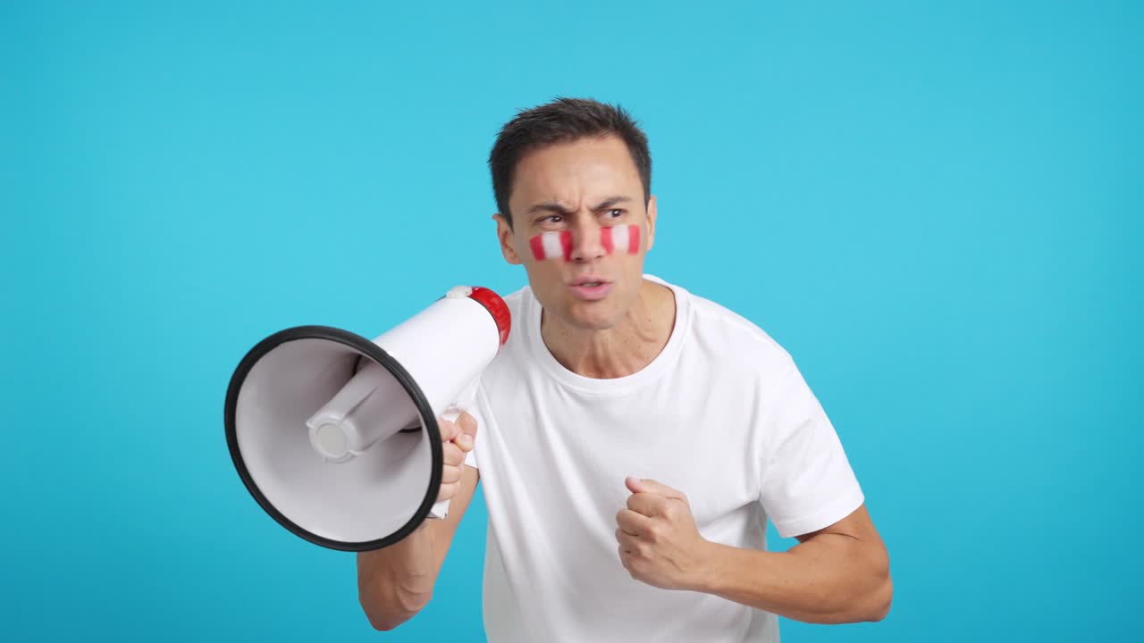 Excited man with peruvian flag on face using a megaphone