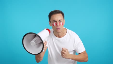 excited man with peruvian flag on face using a megaphone