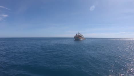 barco de turistas en el hermoso océano azul con vistas al mar desde el punto de vista del barco con reflejo de luz solar en el agua