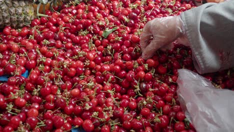 persona que compra cerezas en el mercado