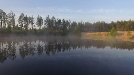 misty morning sunlight over autumn forest lake and scenic countryside landscape aerial wide view