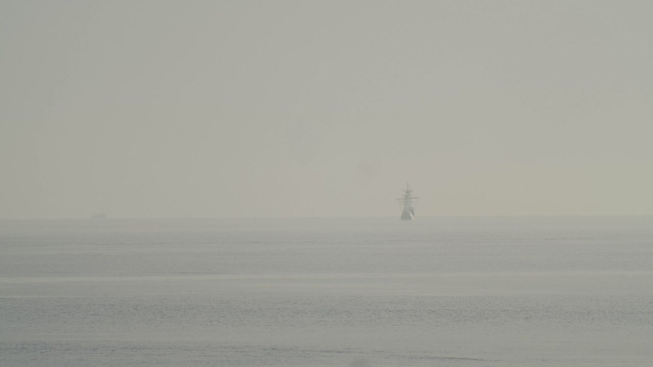 페르디난드 마젤란 나오 빅토리아 카락 보트 복제품은 슬로우 모션 60fps로 잔잔한 바다에서 일출 시 지중해의 멀리 항해합니다.