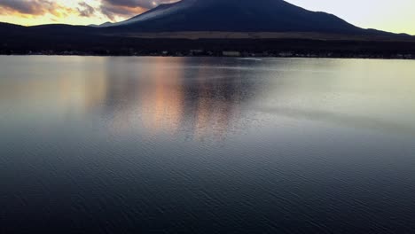 mount fuji at sunset reflecting on a calm lake, clouds gently passing by, serene and majestic