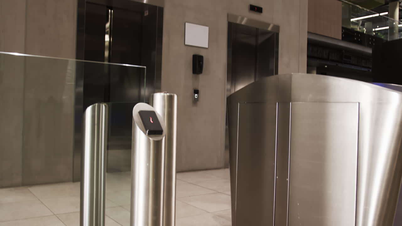 Turnstile gate with card reader controlling access in modern office building