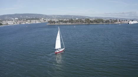 un velero se desliza lentamente mientras la cámara se desplaza hacia arriba para revelar la bahía