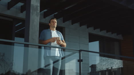 Handsome-man-drinking-coffee-in-modern-exterior-outside.-Casual-man-enjoy-tea.