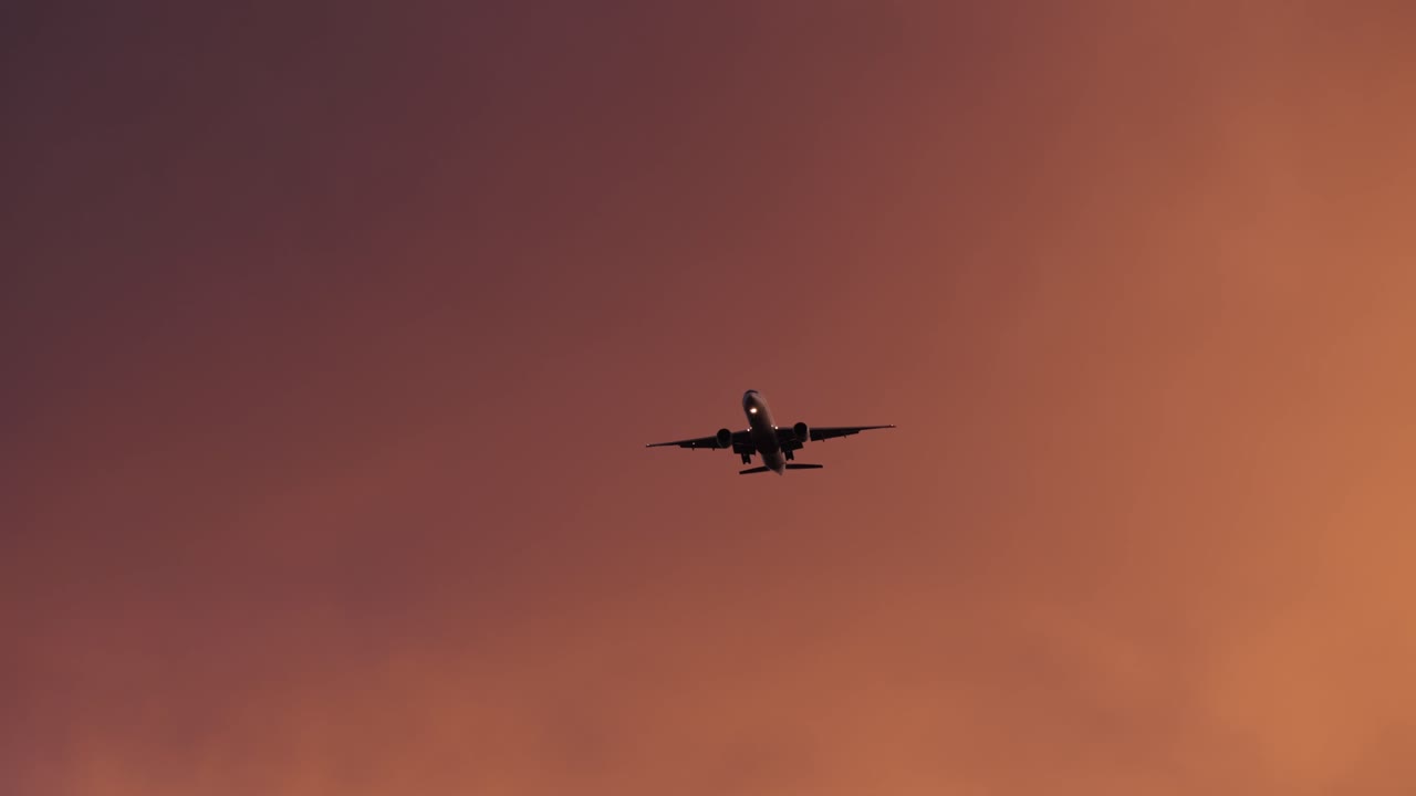 Silhouette Plane Flying In Dramatic Sky - Low Angle Shot