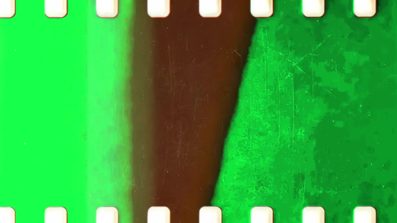 Striscia di pellicola vintage con schermo verde e graffi che si muove orizzontalmente
