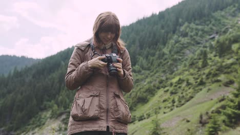 a young woman hiker climbs mountains with photo camera. transfagarasan, carpathian mountains in romania