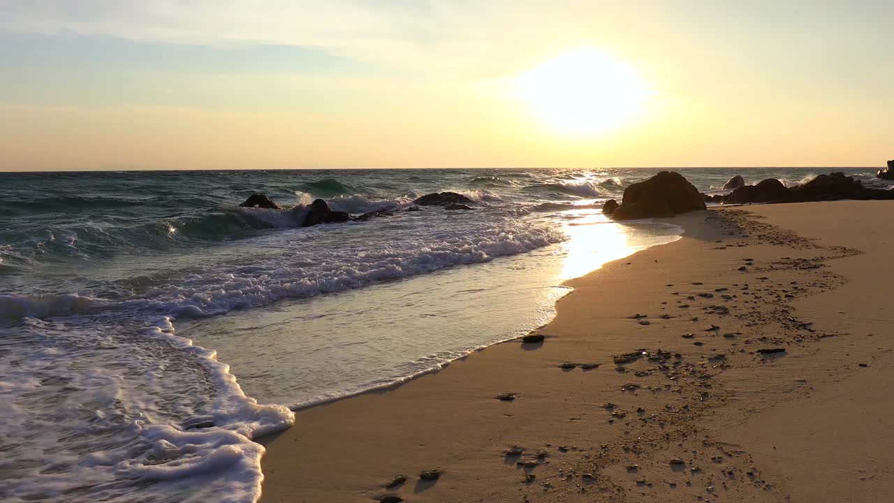 de hermosas olas y playa de arena al amanecer en el mar de andamán.