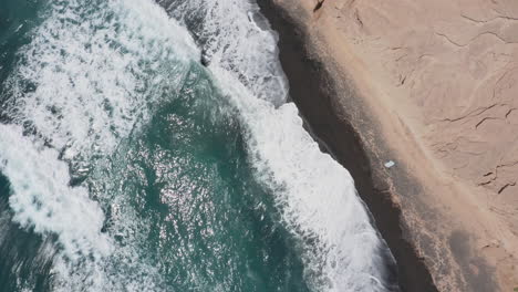 aerial: top down view of vlychada beach in santorini, greece on a sunny day