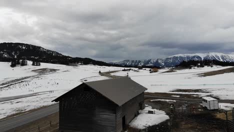 drone shot of a barn in a rural area during winter