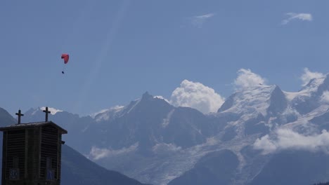 paraglider flying in front of the snowy french alps