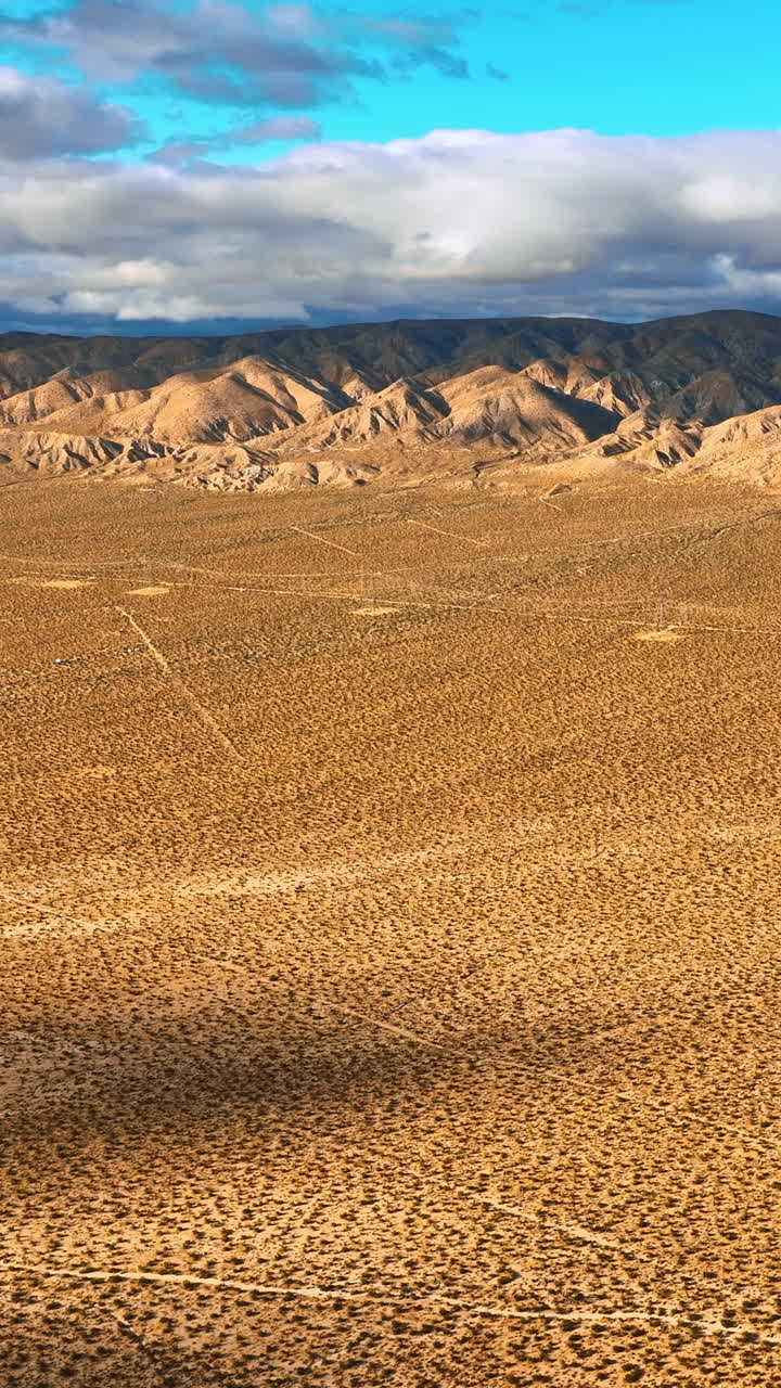 Beautiful scenery of Nevada desert on daytime. Drone footage approaching stunning mountains topped with clouds. Vertical video