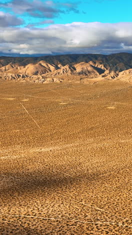 beautiful scenery of nevada desert on daytime. drone footage approaching stunning mountains topped with clouds. vertical video
