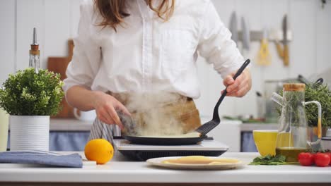 cook flipping a pancake in the frying pan