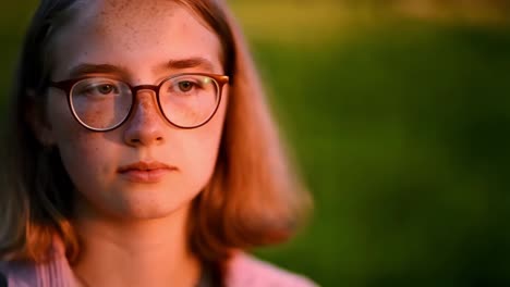 teenage girl in glasses, outdoor portrait at sunset