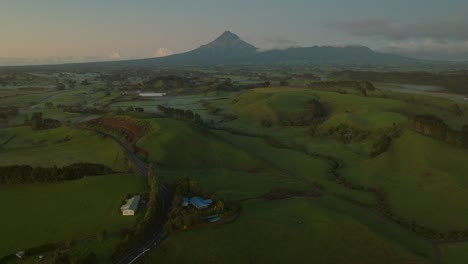 beautiful mount taranaki volcano with green grassland in basin, aerial