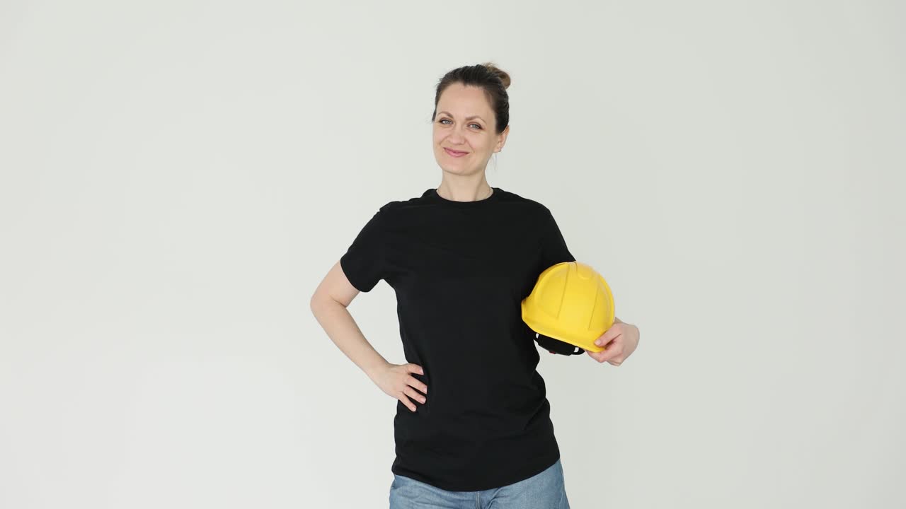 Woman holding a yellow hard hat and smiling